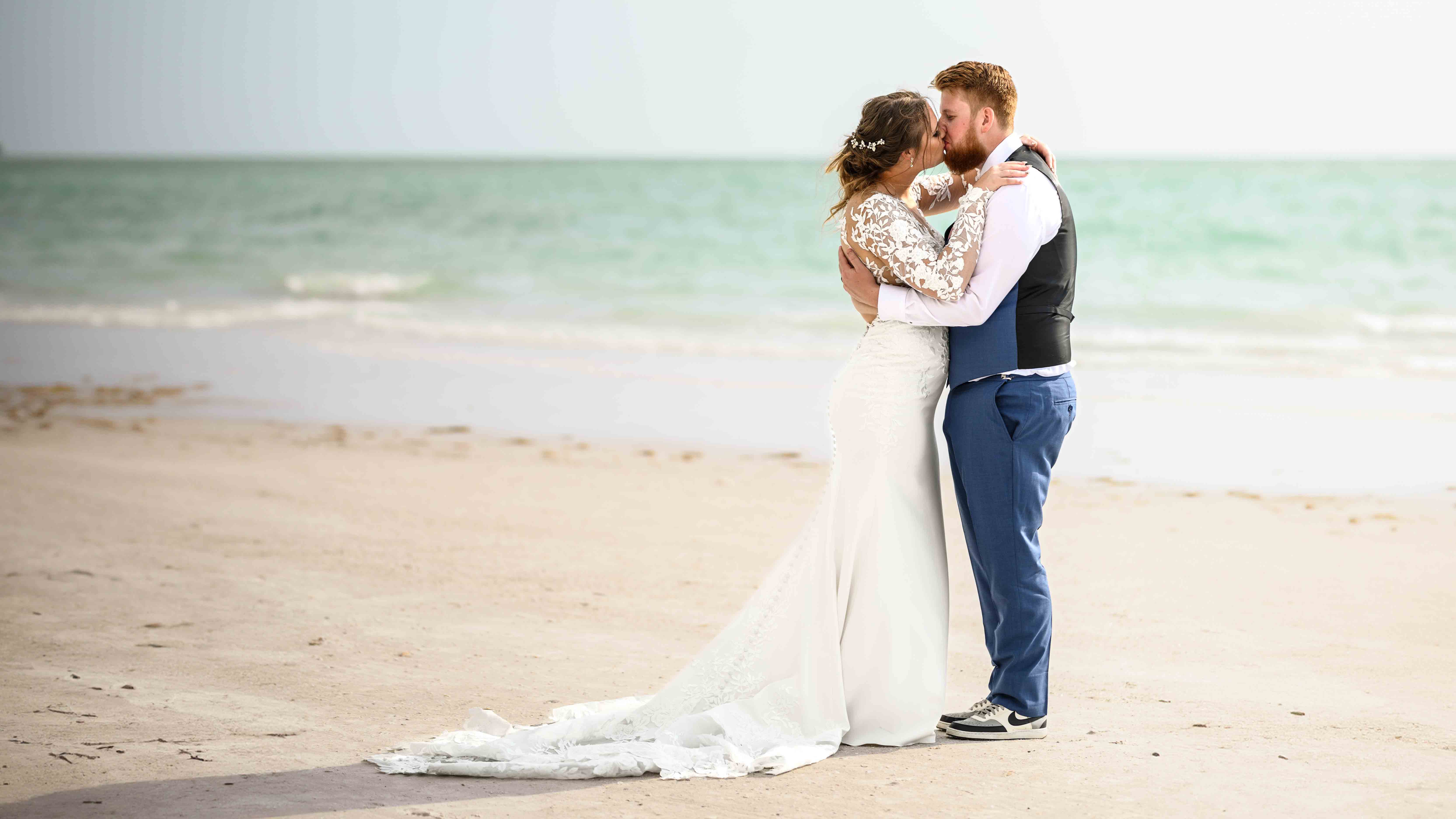 Newlywed couple kissing on the beach