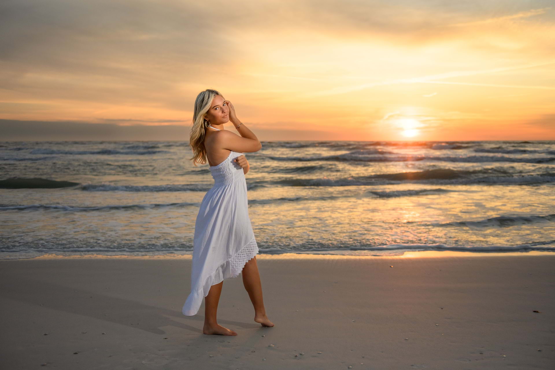 Photo of a young girl on a beach during sunset